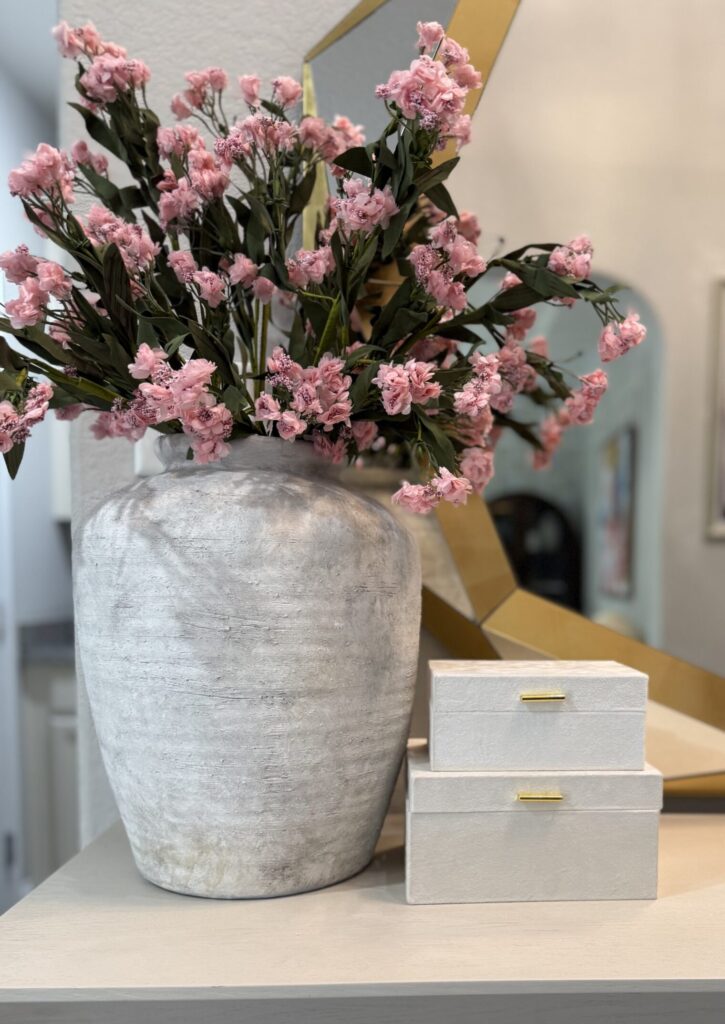 Pink floral arrangement and textured vase used to style a credenza in Cypress, Texas.